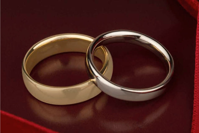 two gold rings on a red shiny background. One is yellow gold and the other is white gold.